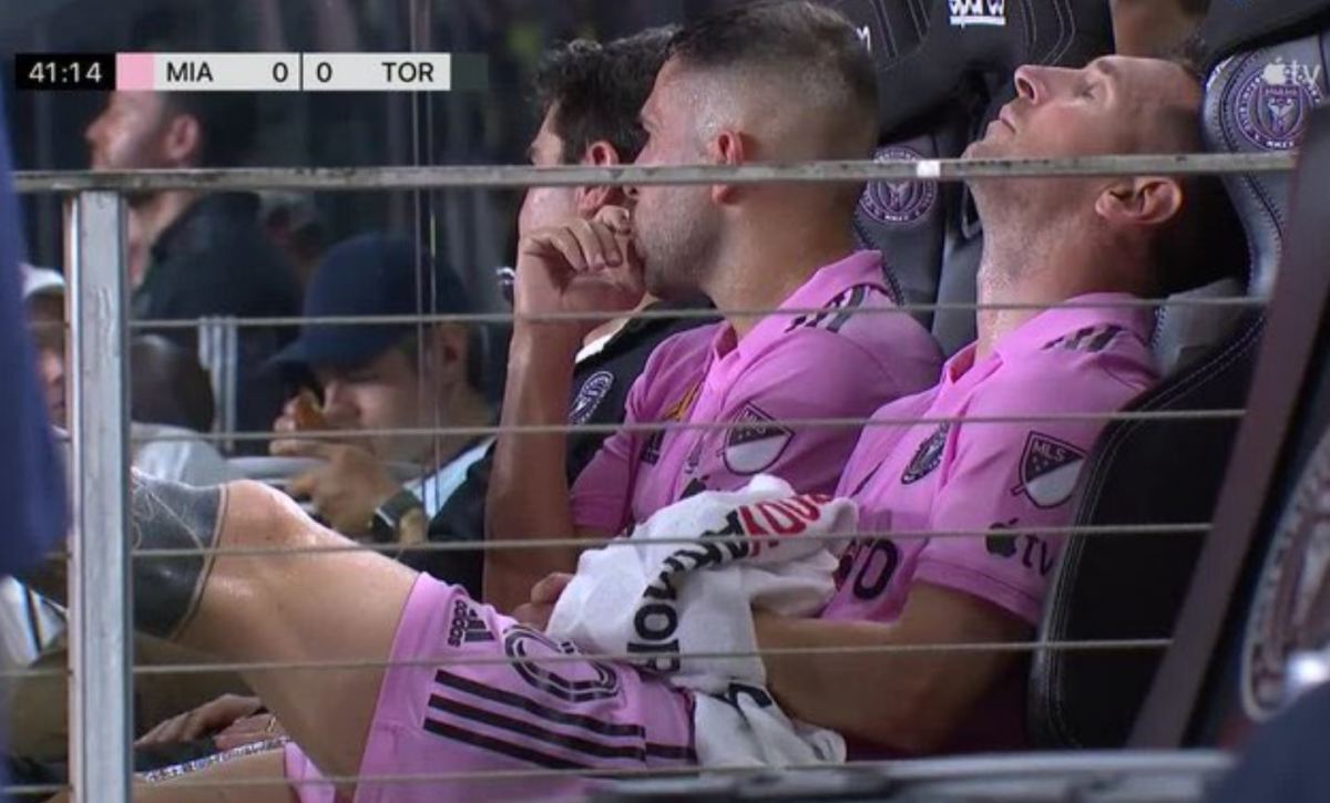 Lionel Messi pictured (right) sat on the Inter Miami bench with his left foot raised after being substituted off during a game against Toronto FC in September 2023